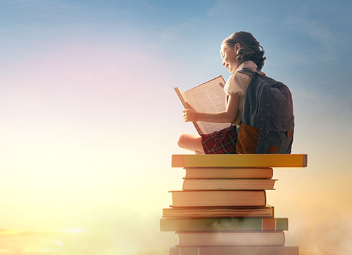 child on the tower of books